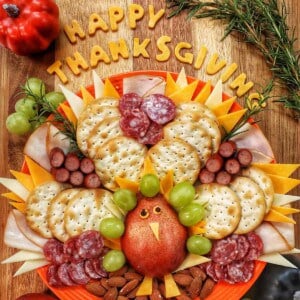beautiful Thanksgiving turkey charcuterie board with cheese, meat, crackers, and fruit.