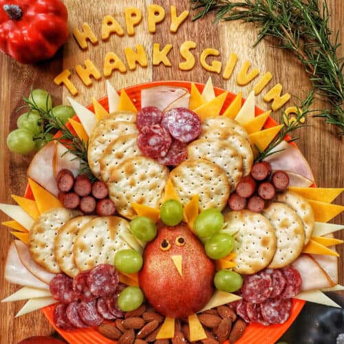 beautiful Thanksgiving turkey charcuterie board with cheese, meat, crackers, and fruit.