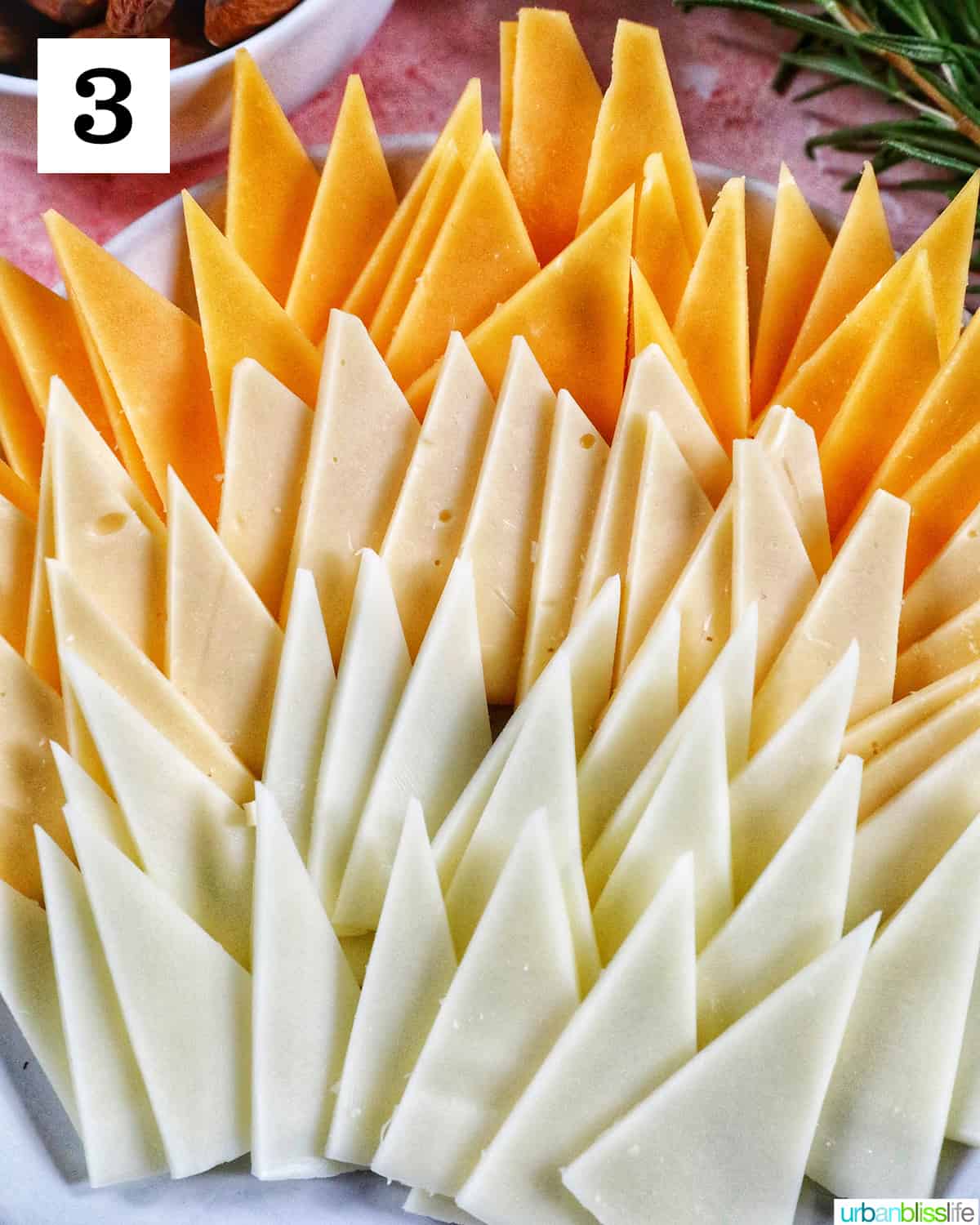 three different kinds of cheese cut into triangles to form a turkey charcuerie board.