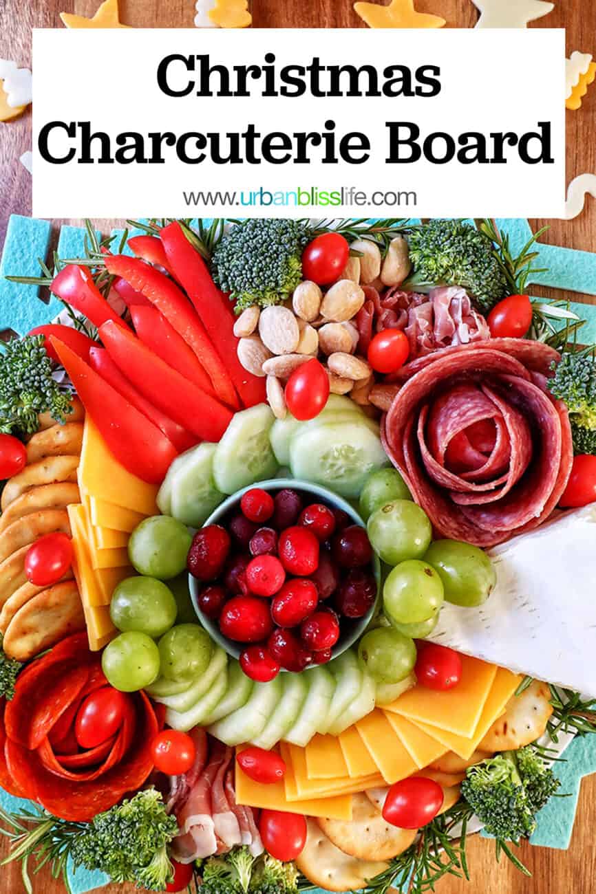 Christmas charcuterie board with variety of meat, cheeses, fruits, vegetables, and nuts.