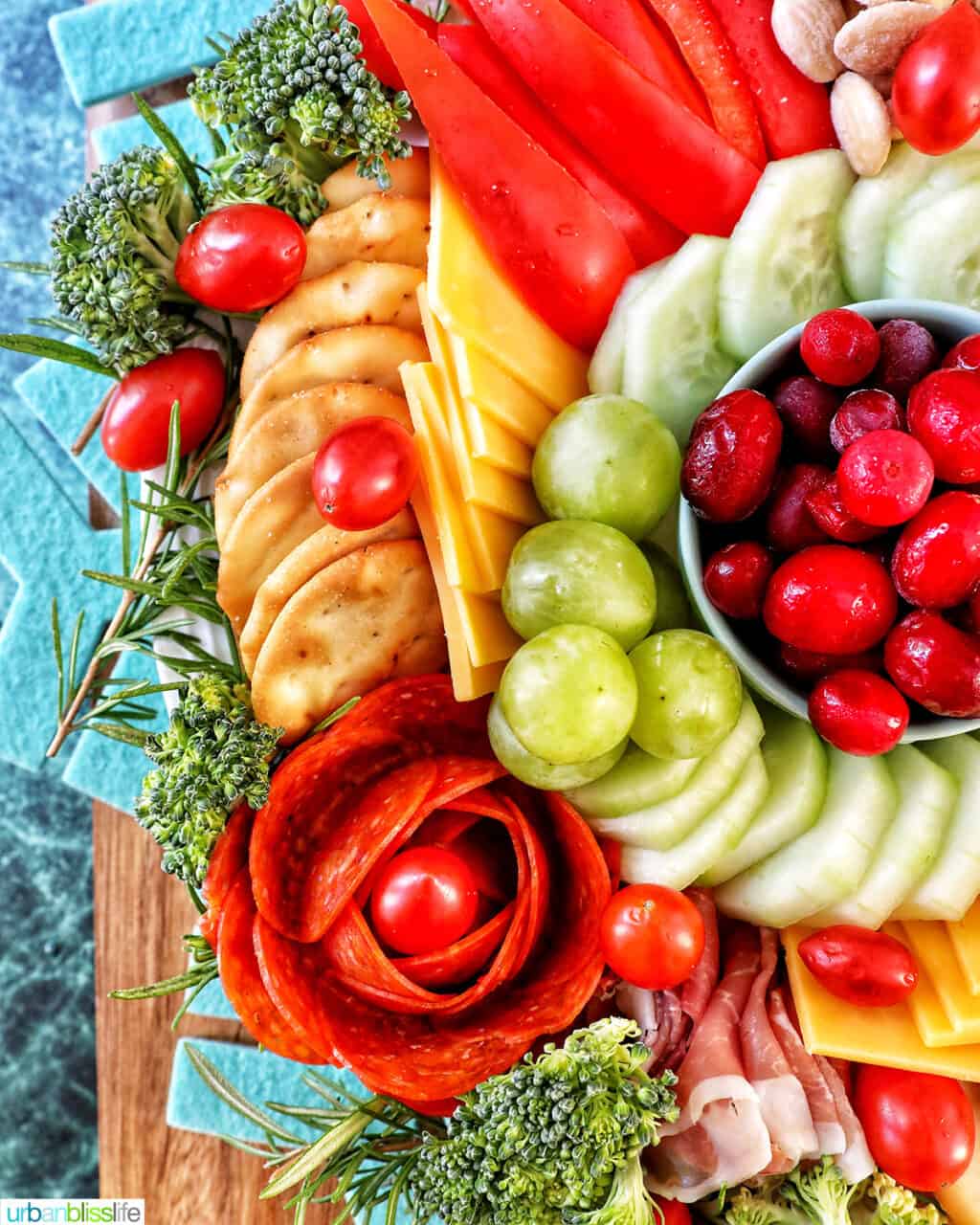 Christmas charcuterie board with variety of meat, cheeses, fruits, vegetables, and nuts.
