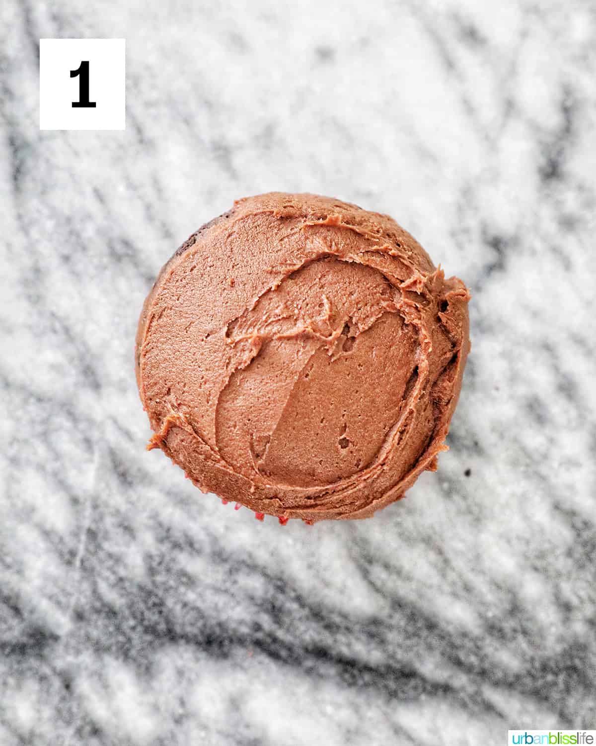 frosted chocolate cupcake on a marble counter.