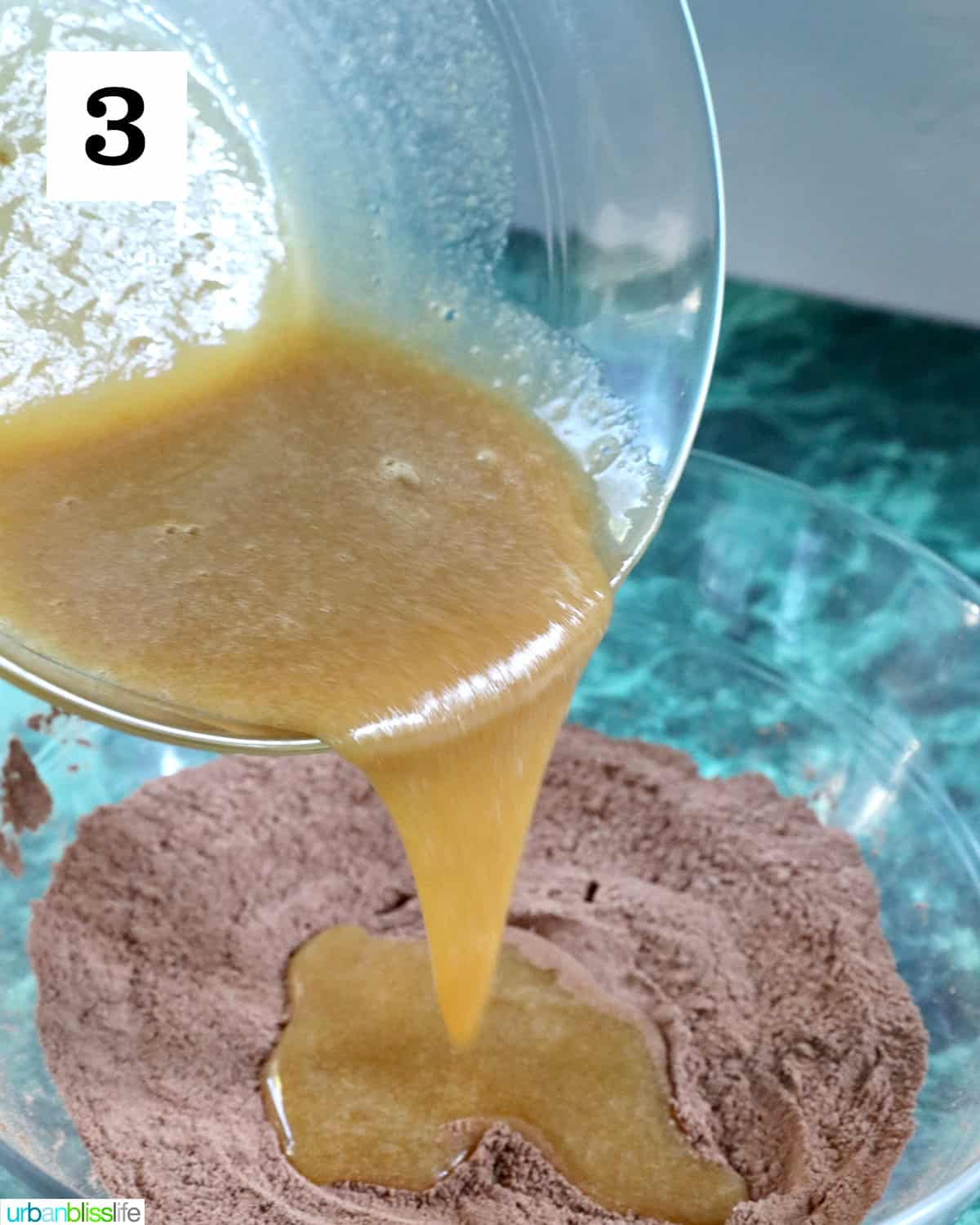 pouring wet ingredients into bowl of dry ingredients while making chocolate cupcakes.