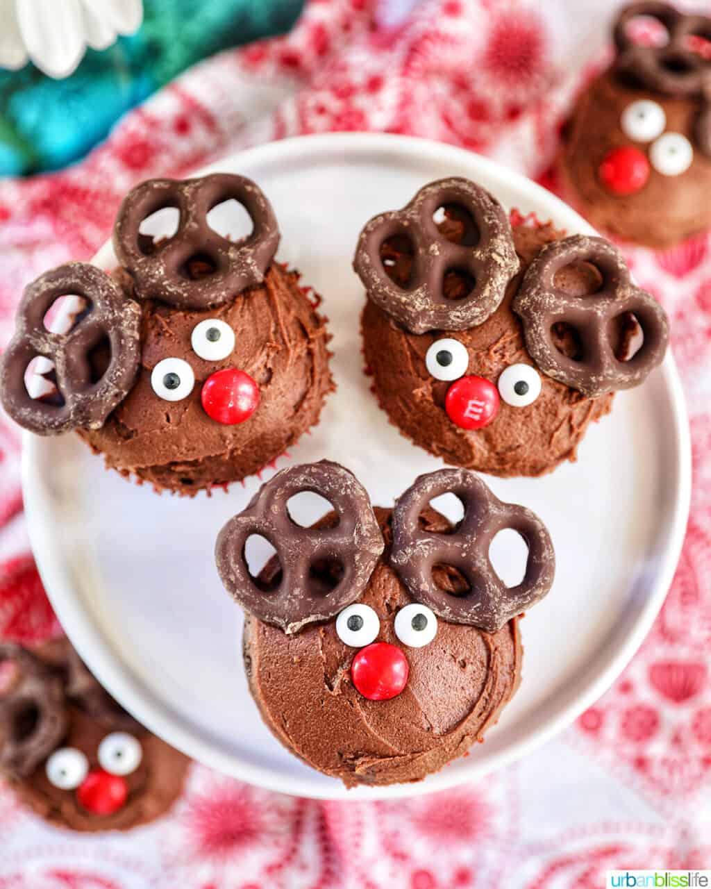 three reindeer cupcakes on a plate.