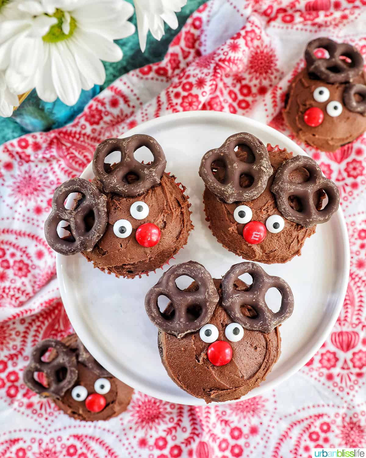 three reindeer cupcakes on a plate.