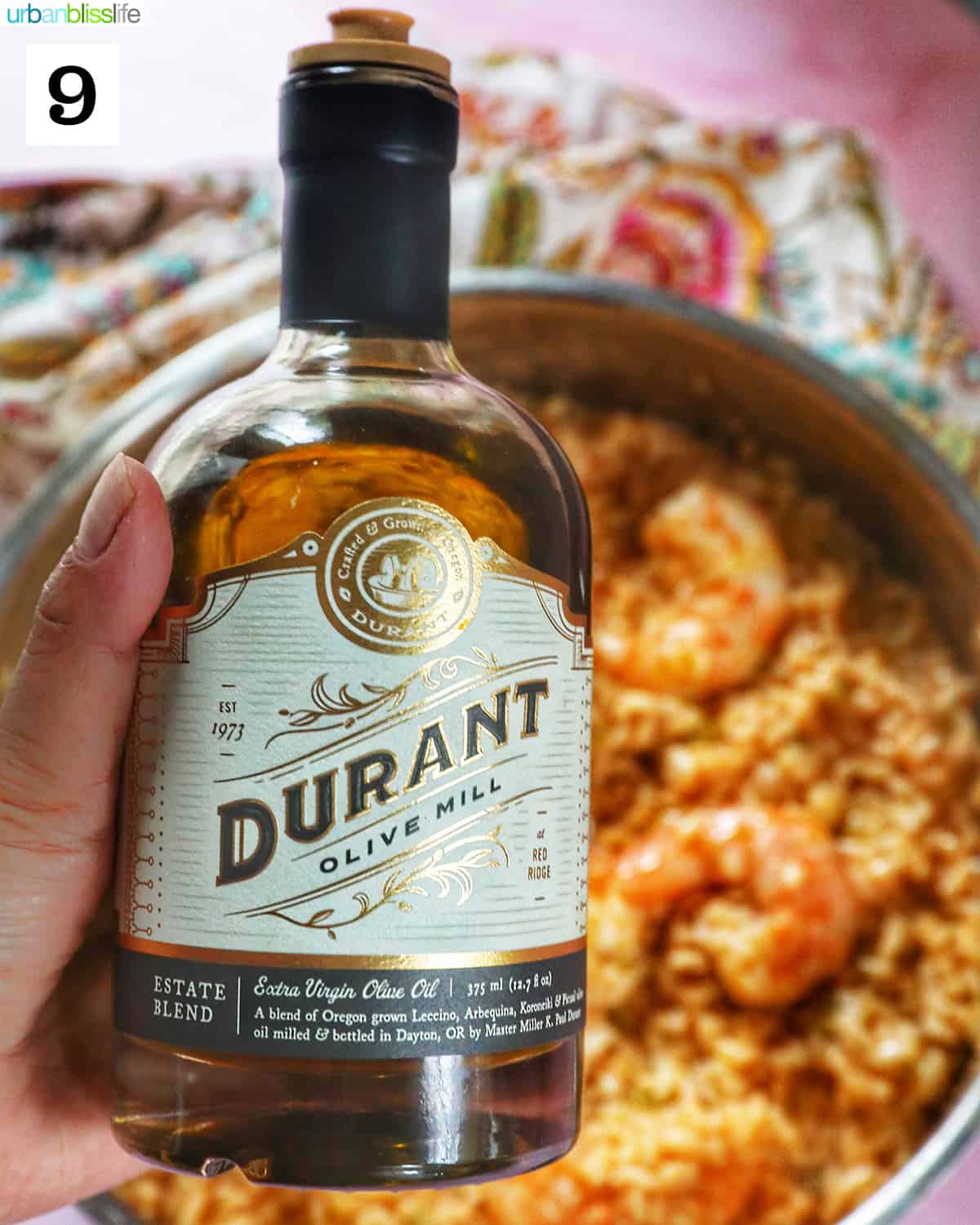 bottle of Durant olive oil above a pan of risotto with prawns.