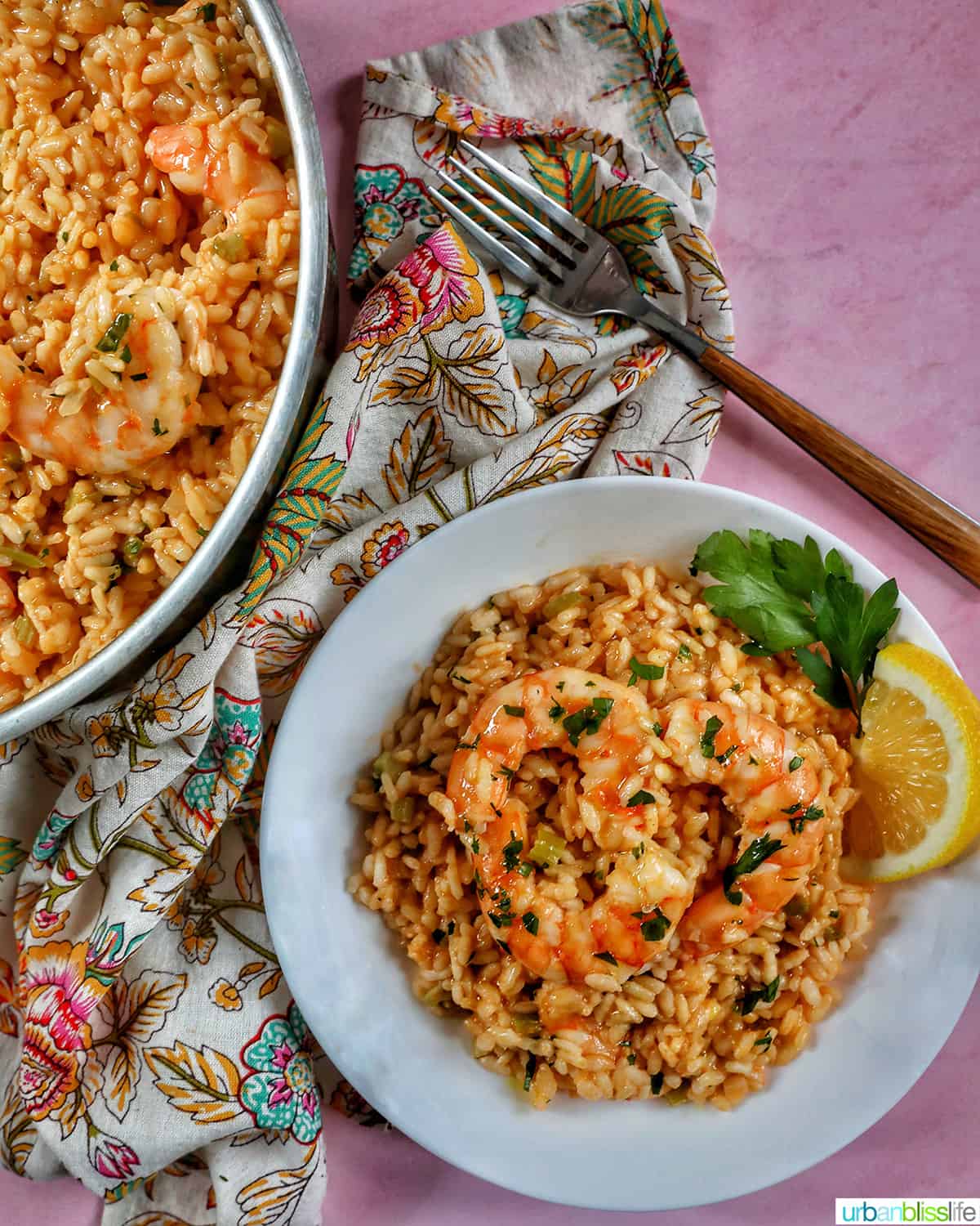 risotto with prawns in a large pan and also in a white bowl with a fork and colorful floral napkin.