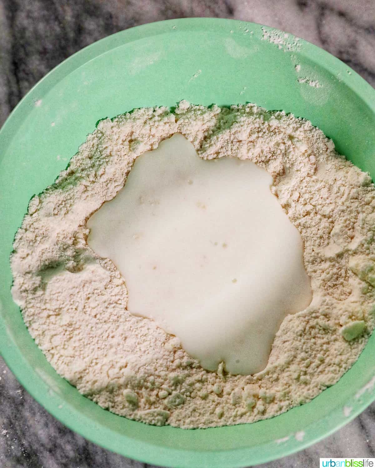 buttermilk poured into a well of dry ingredients to make biscuits.