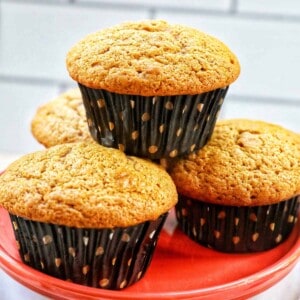 Stacks of pumpkin banana muffins on an orange plate.