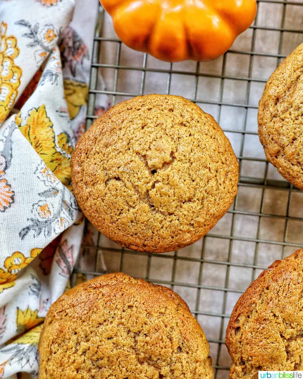 closeup of a few pumpkin banana muffins on a cooling rack.
