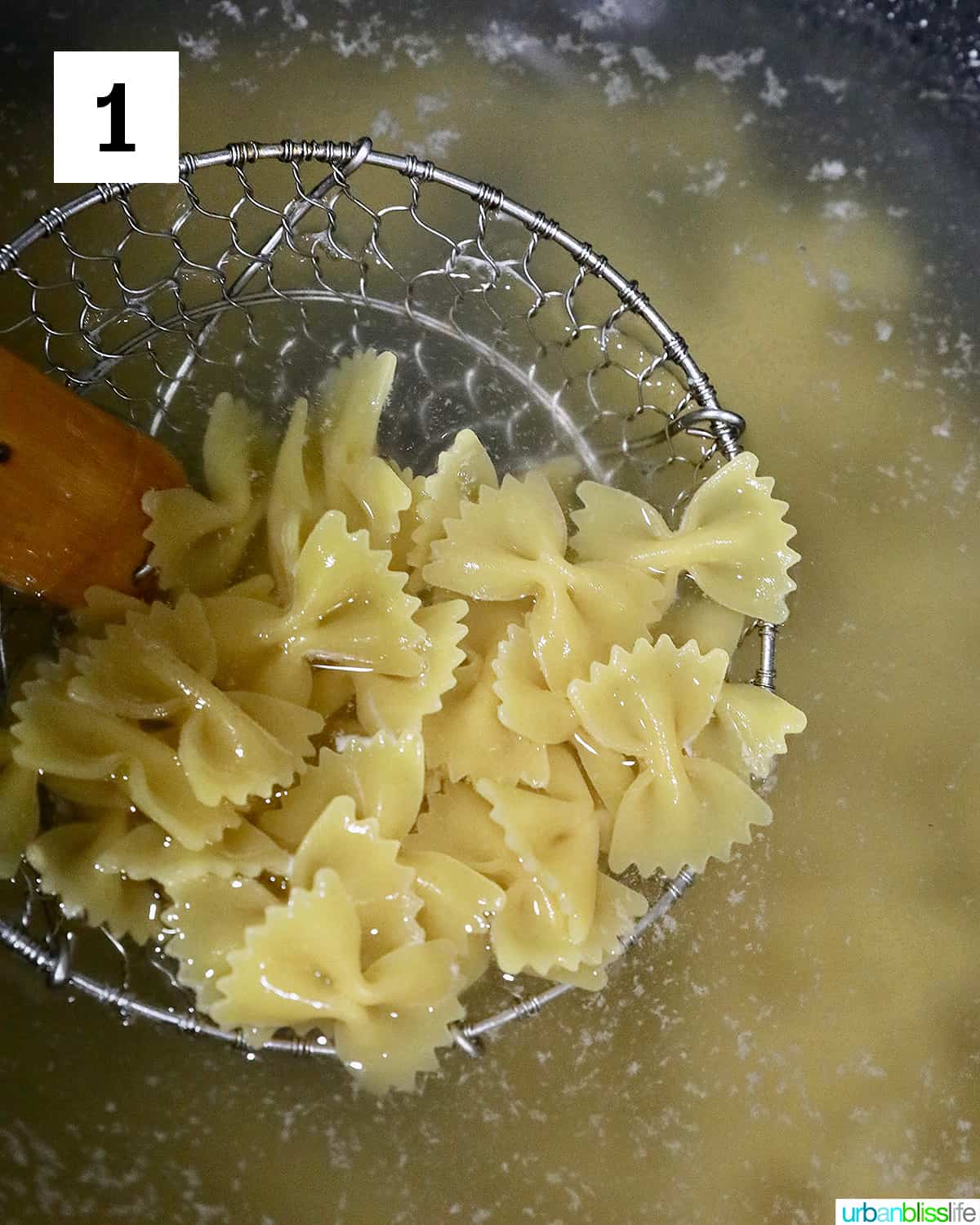 straining bow tie pasta out of boiling water.