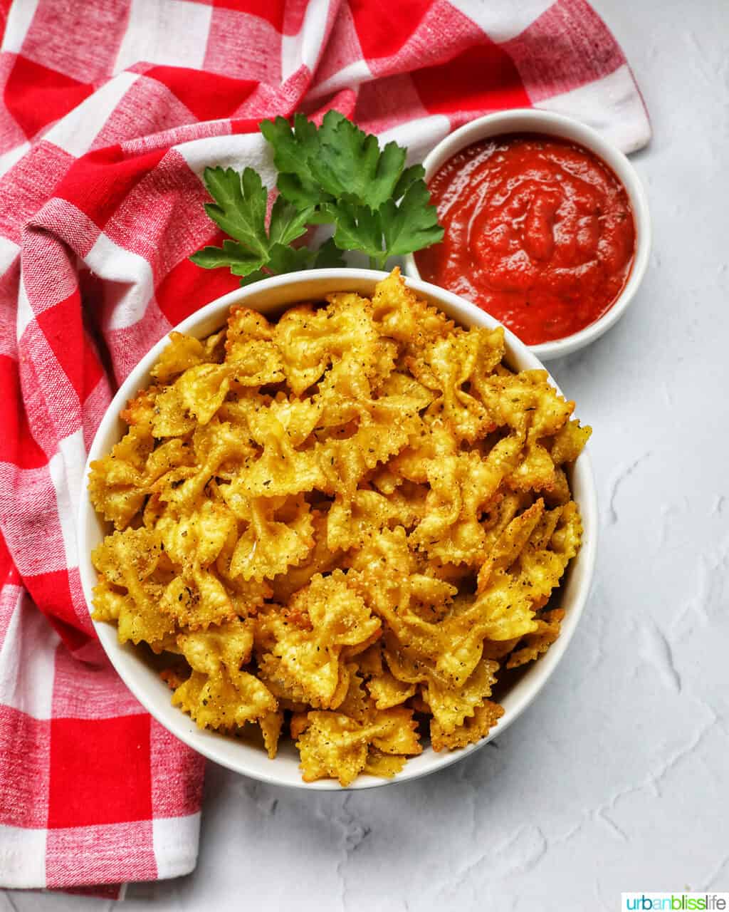 bowl of Air Fryer Pasta Chips with a red and white checker napkin.