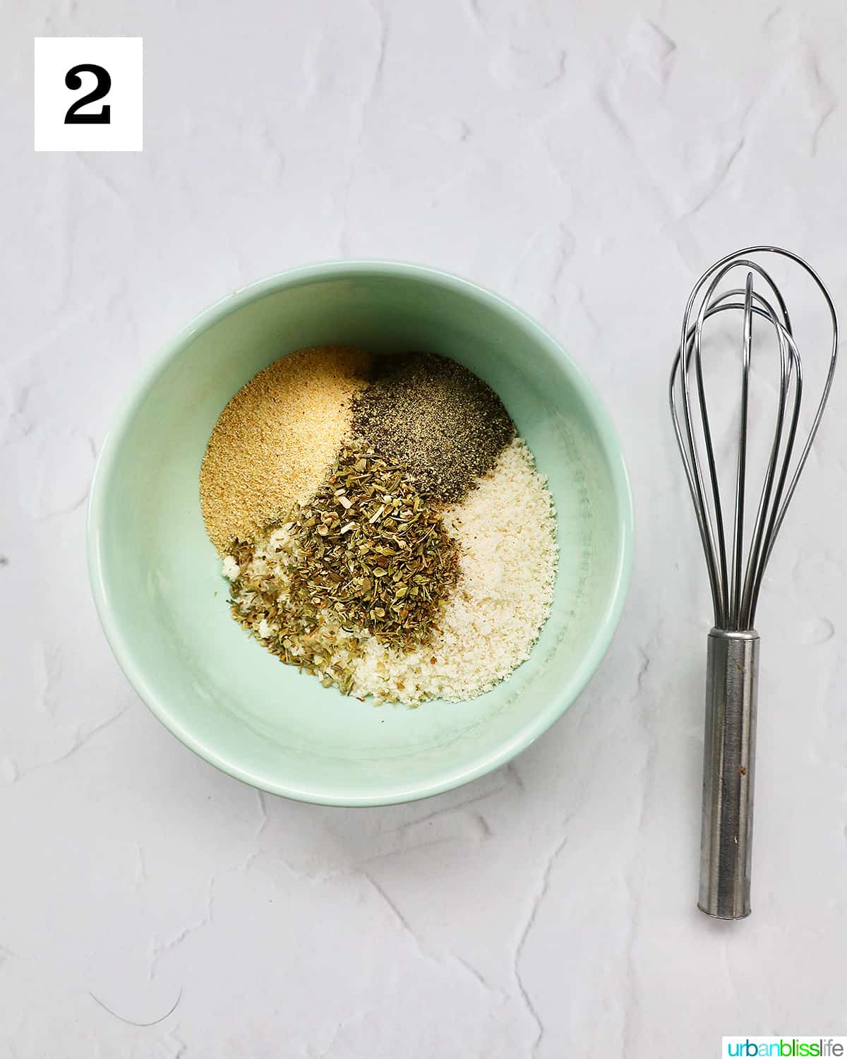bowl of seasoning mix next to a whisk.