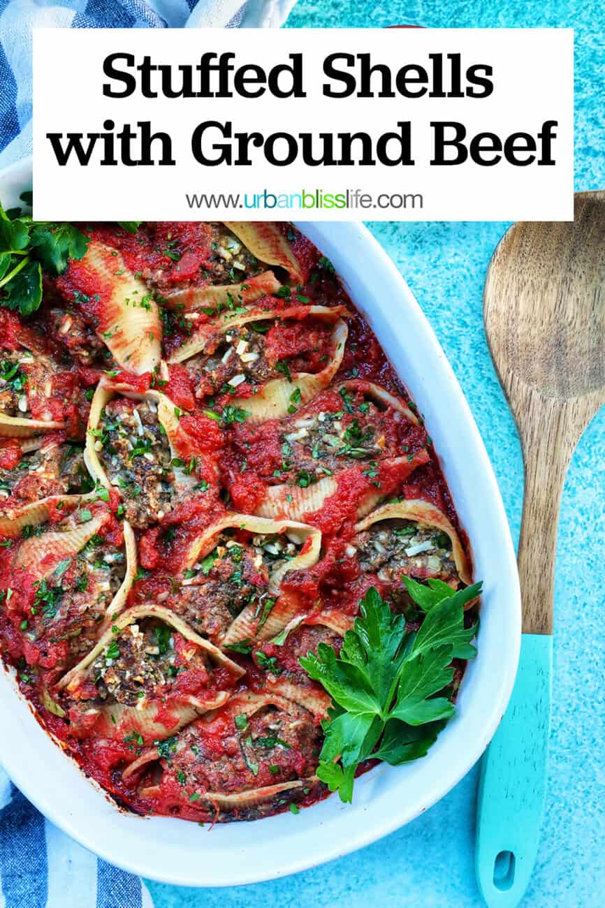 casserole dish of stuffed shells with ground beef with a wooden spoon and side of dairy free parmesan cheese and title text overlay.