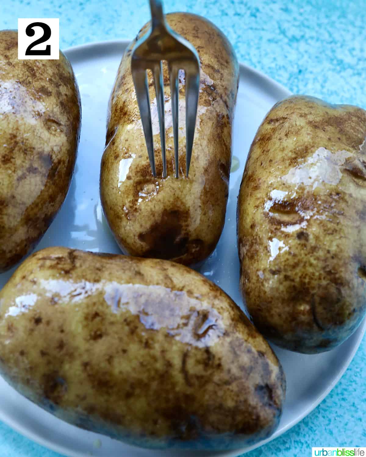 fork piercing baked potatoes.