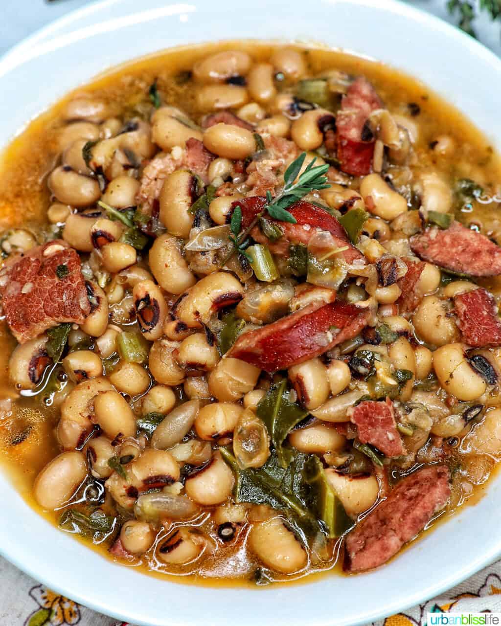 Instant Pot black eyed peas with scoop of white rice in a white bowl.
