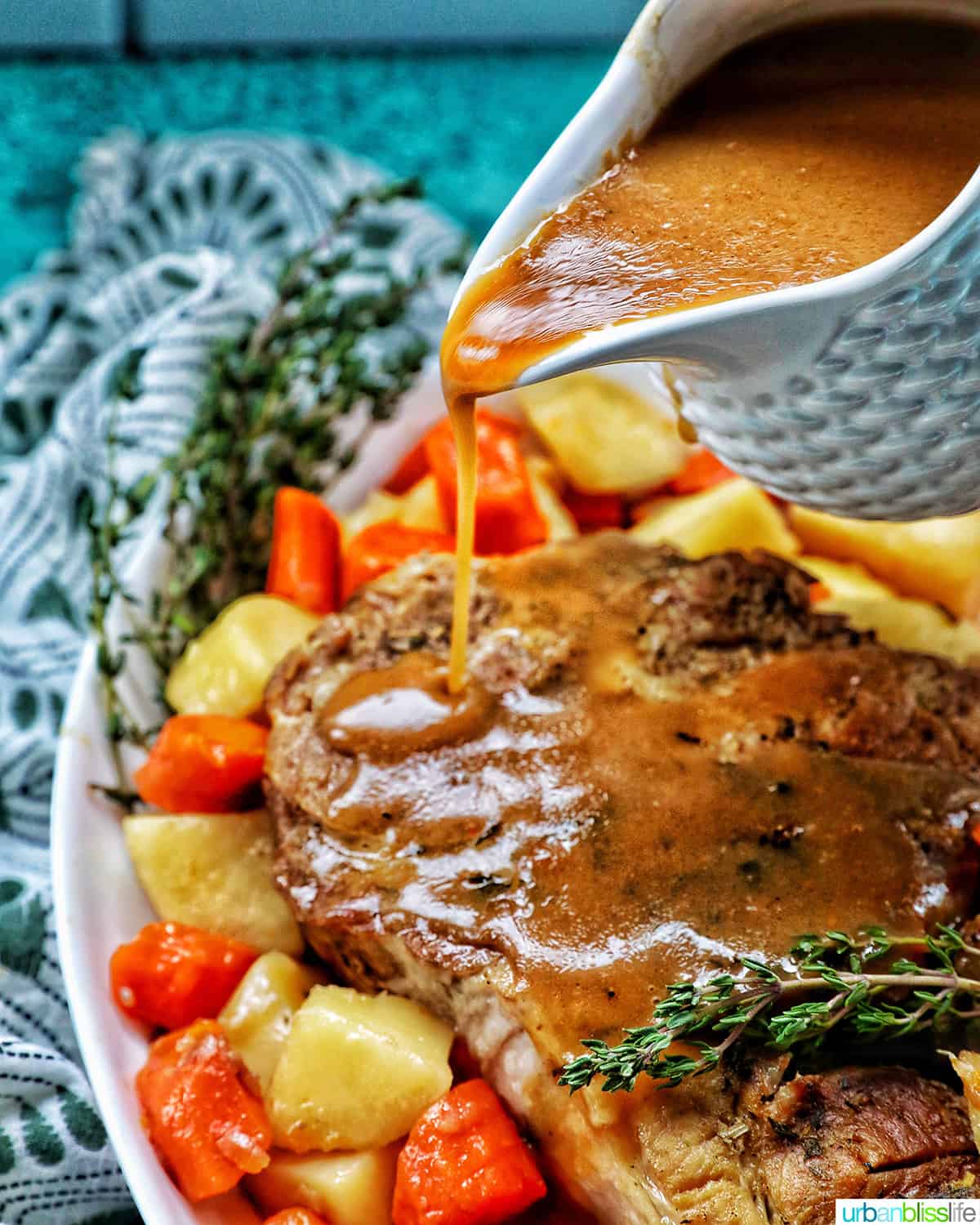 pouring gravy over instant pot pork roast, carrots, and potatoes.