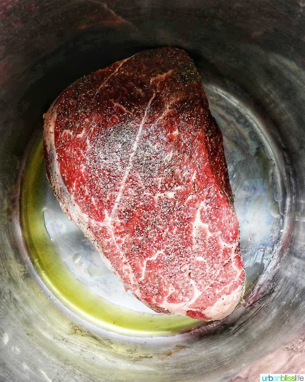 seasoned sirloin beef roast in the Instant Pot with olive oil, searing.