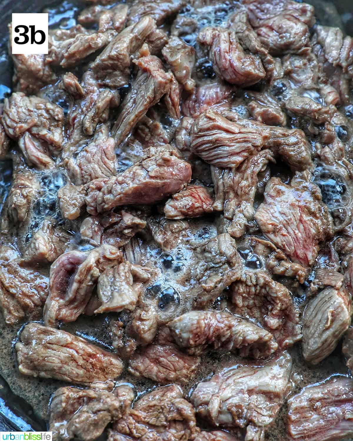 steak cooking in a cast iron skillet.