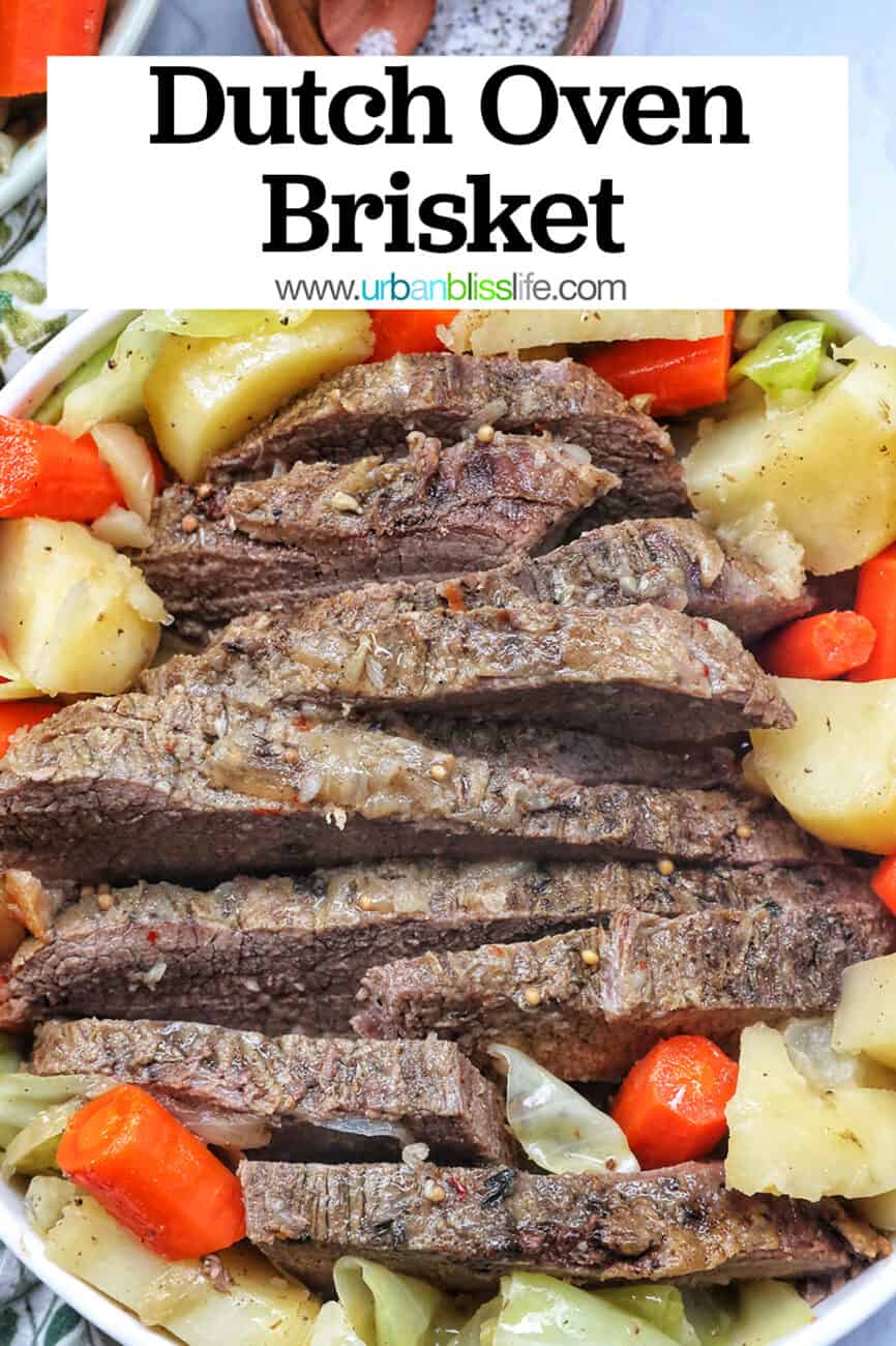 bowl of sliced dutch oven brisket with carrots, potatoes, and cabbage with title text that reads Dutch Oven Brisket.