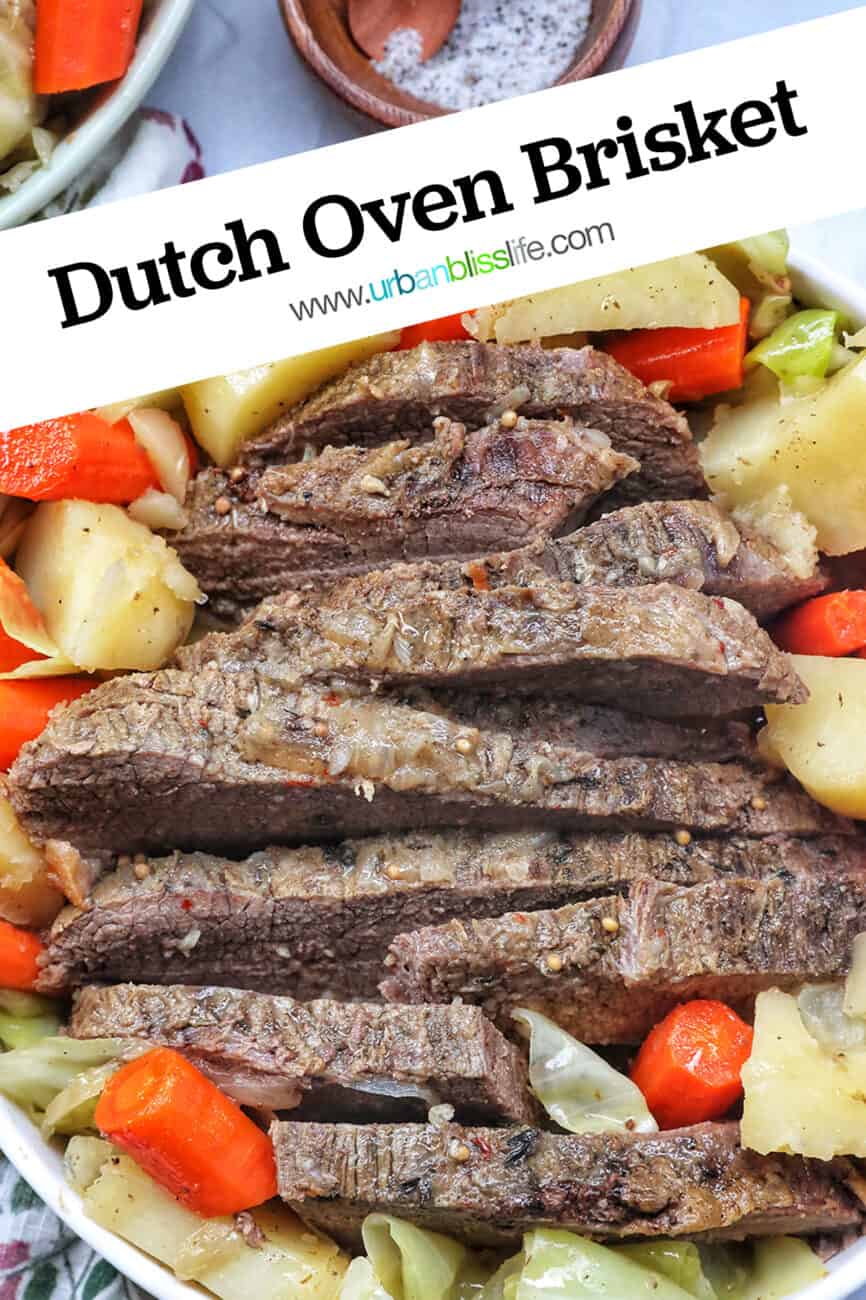 bowl of sliced dutch oven brisket with carrots, potatoes, and cabbage with title text that reads Dutch Oven Brisket.