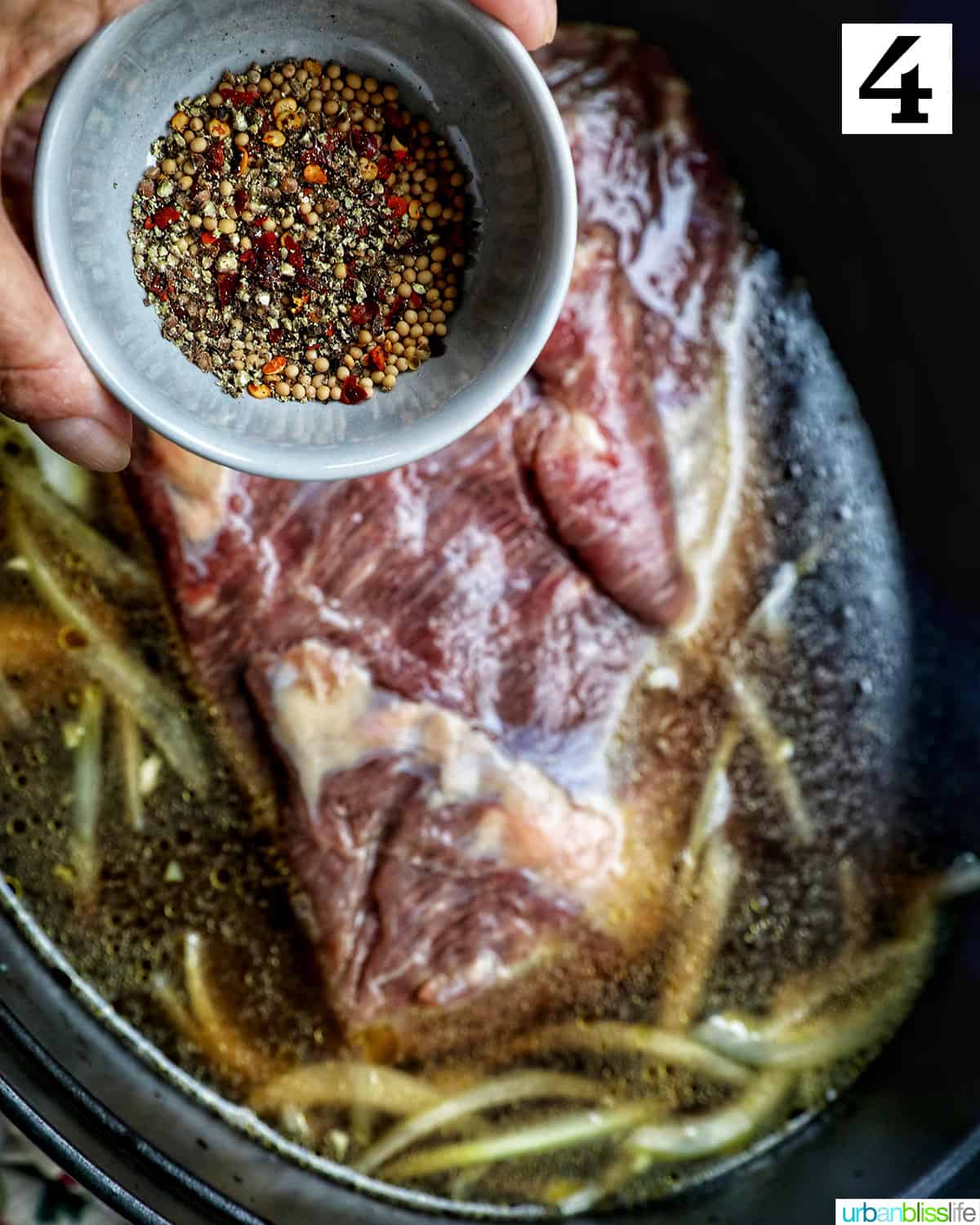 bowl of seasoning above a dutch oven with brisket and braising liquid.