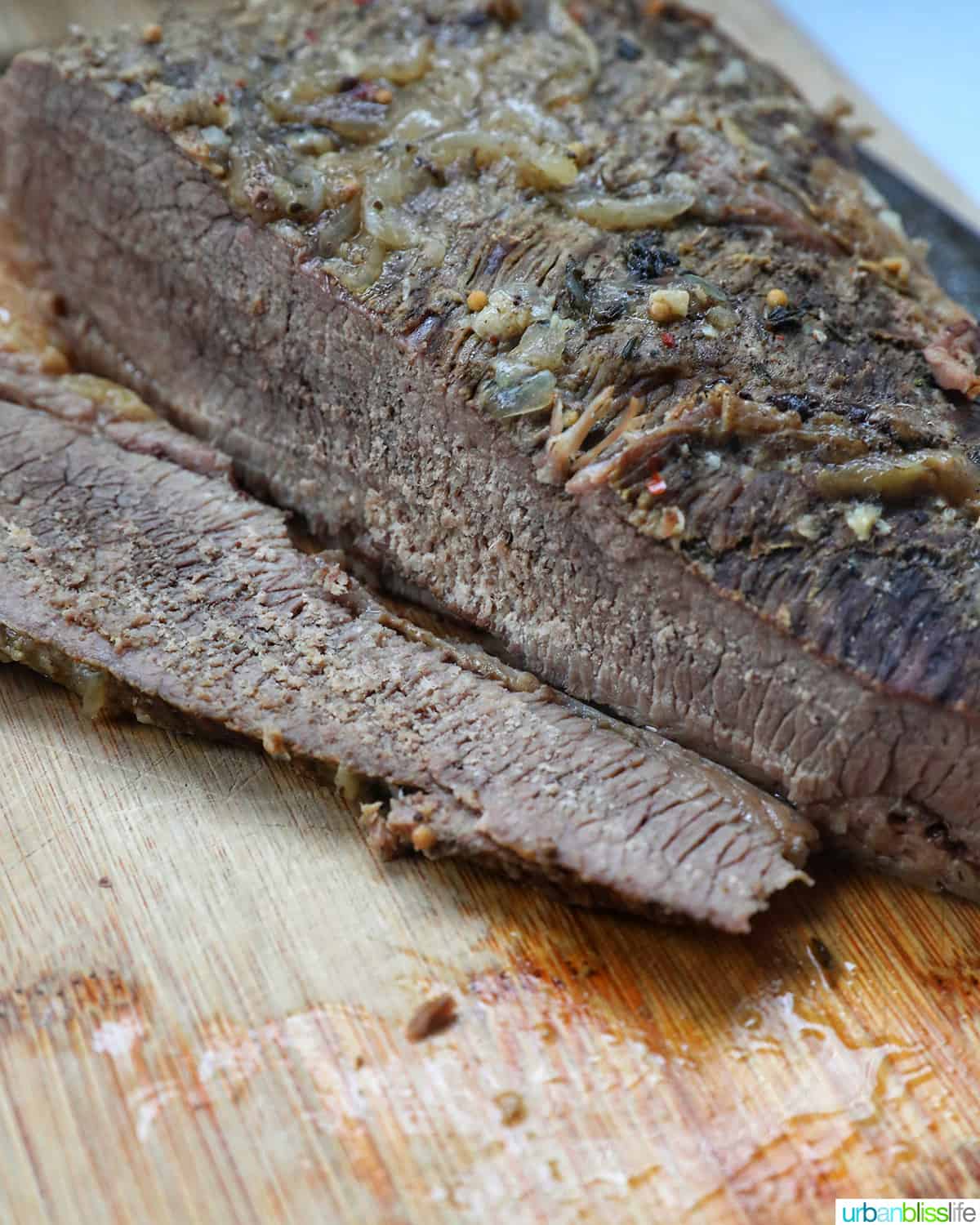 sliced brisket cooked in a dutch oven on a cutting board.