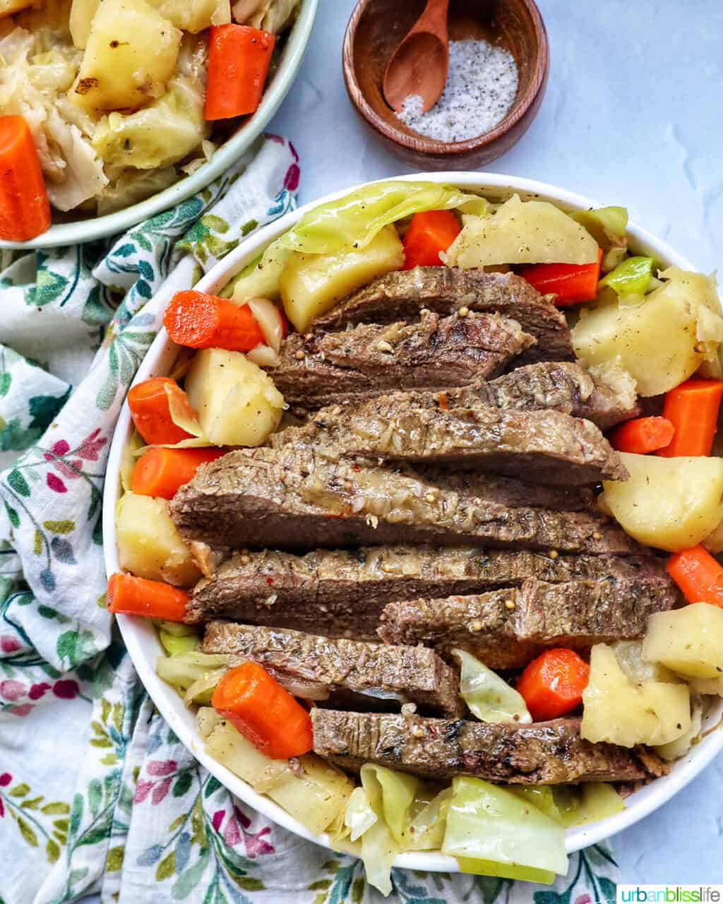bowl of sliced dutch oven brisket with carrots, potatoes, and cabbage.