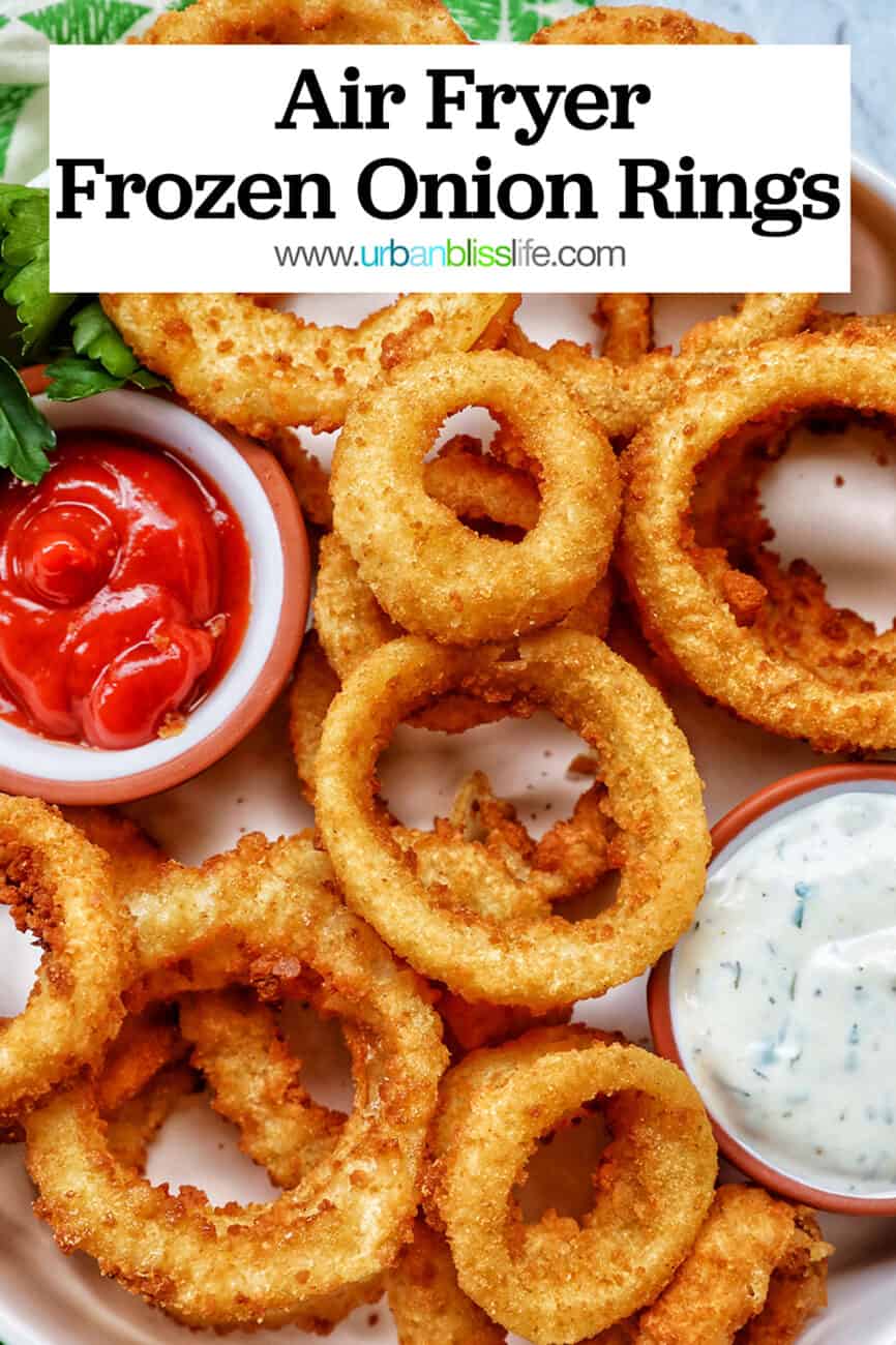 bowl of air fryer onion rings with sides of ranch dressing and ketchup with text that reads Air Fryer Onion Rings.