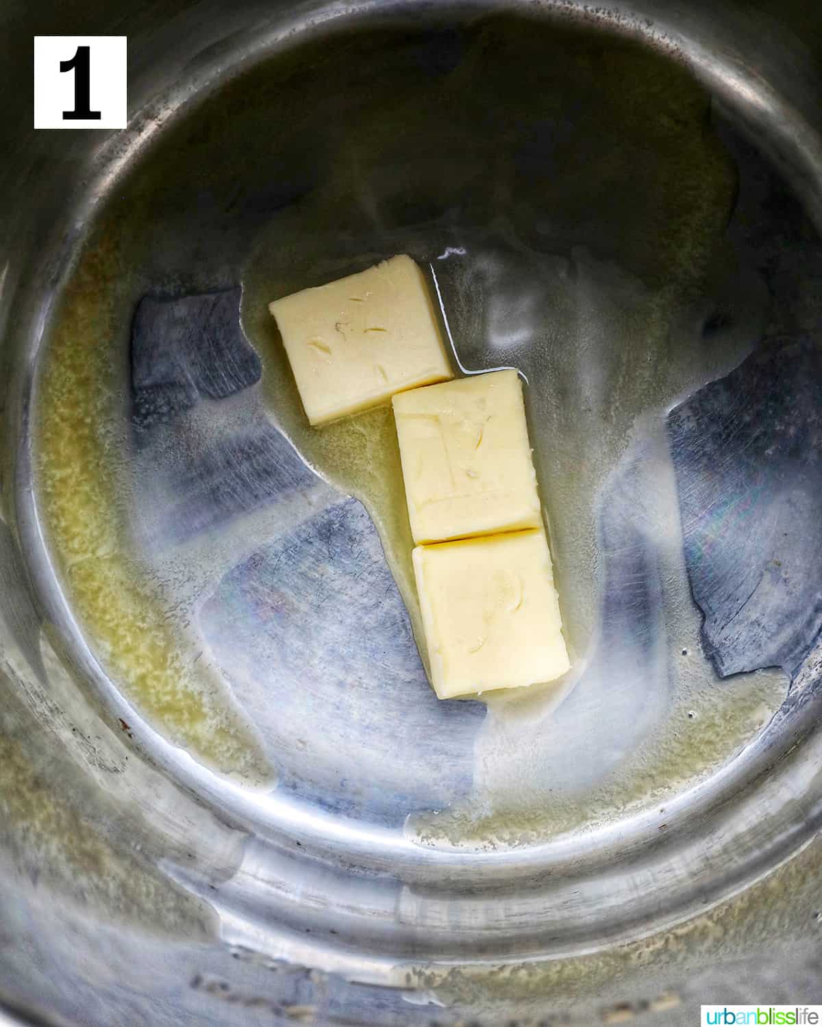 three pats of butter melting in an instant pot.