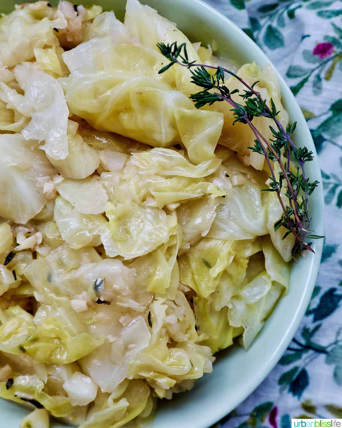bowl of cooked instant pot cabbage with thyme sprigs.