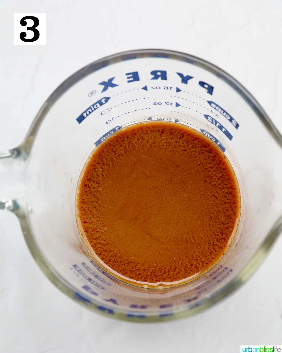 liquid measuring cup with instant coffee, whiskey and cream mixed for Irish coffee cake.