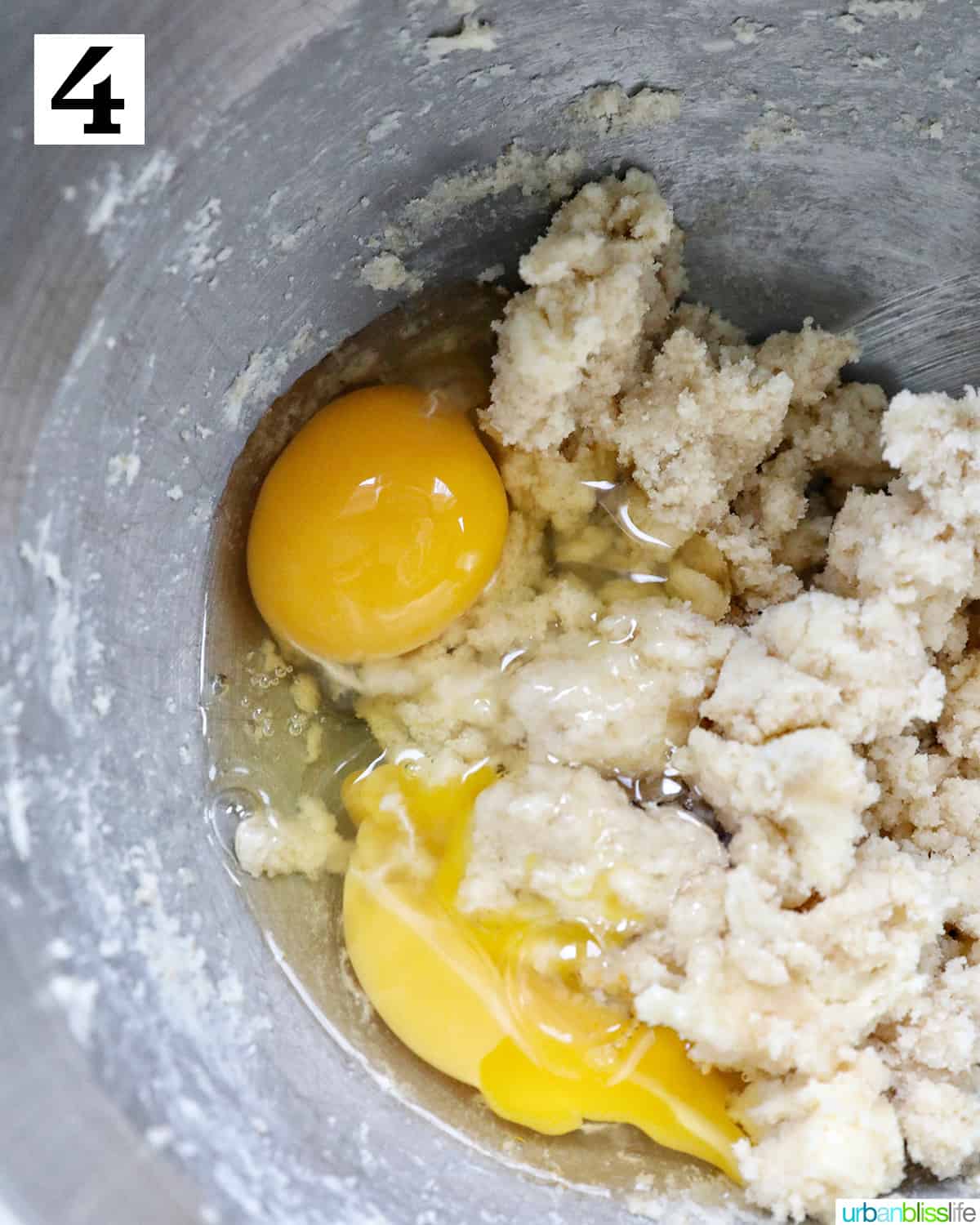 eggs added to a stand mixer bowl with dough.