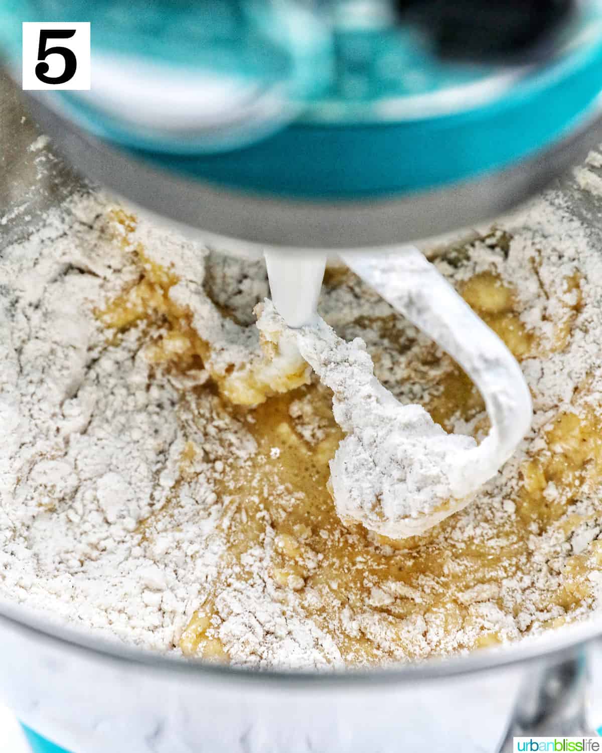 adding dry ingredients to wet ingredients in a stand mixer.
