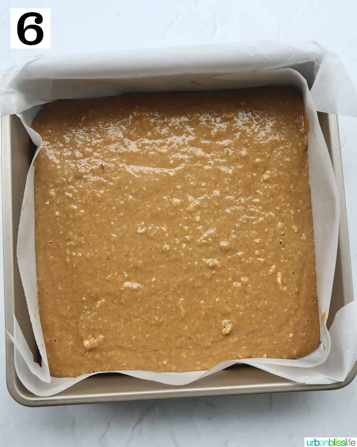 wet batter for irish coffee cake poured into a parchment paper lined baking pan.