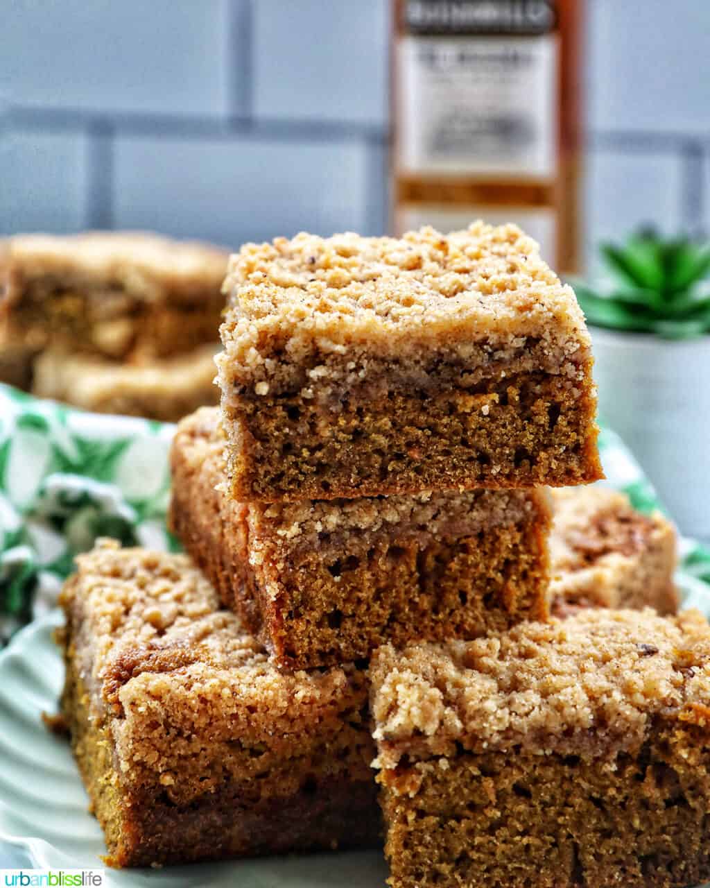 stack of Irish coffee cake on a green plate with green patterned napkins and bottle of Irish whiskey.