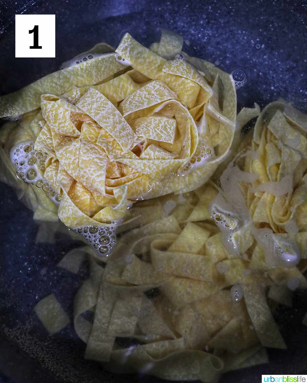 pappardelle pasta being added to a pot of boiling water.