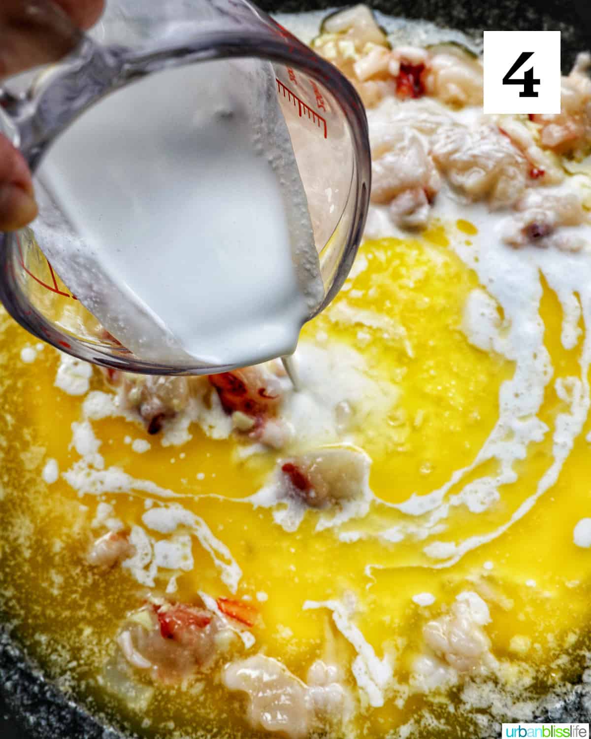 pouring cream into lobster pasta sauce in a skillet.