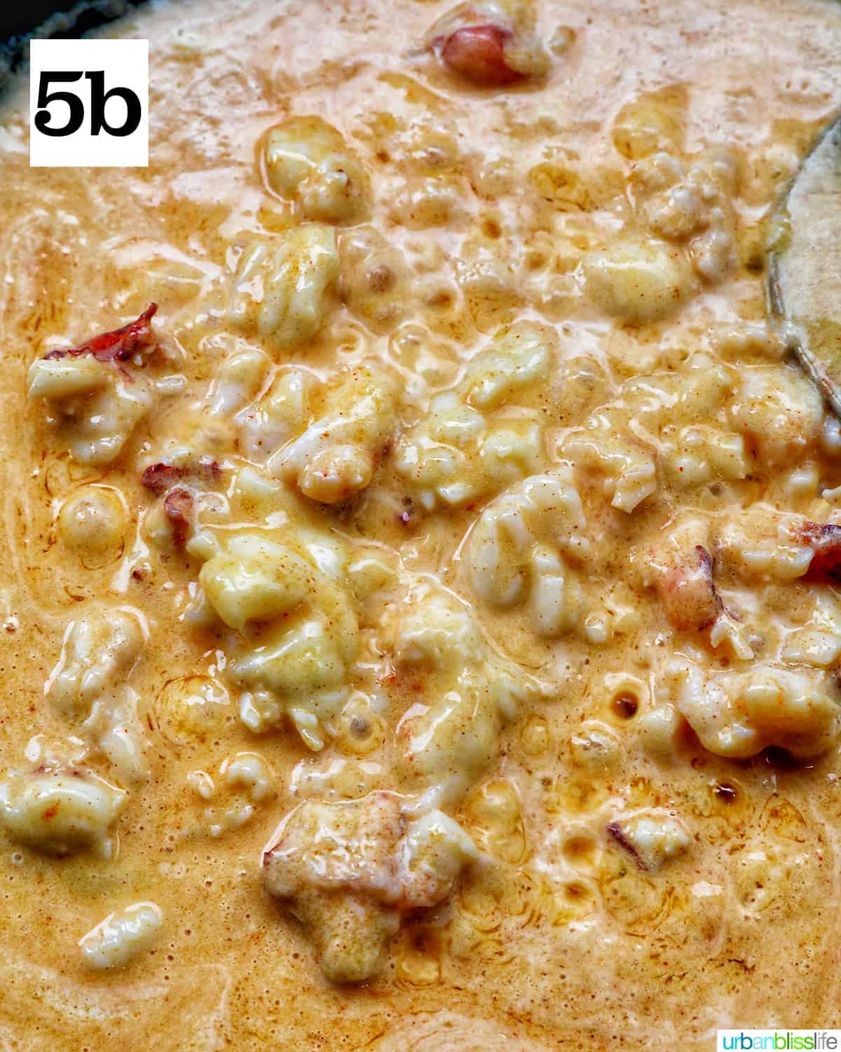 lobster and dairy free cream sauce bubbling in a skillet.