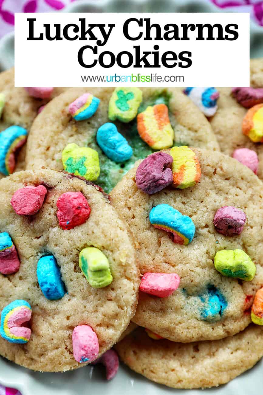 plate full of Lucky Charms Cookies on top of one another at angles with bright colorful marshmallows with text reading Lucky Charms Cookies.