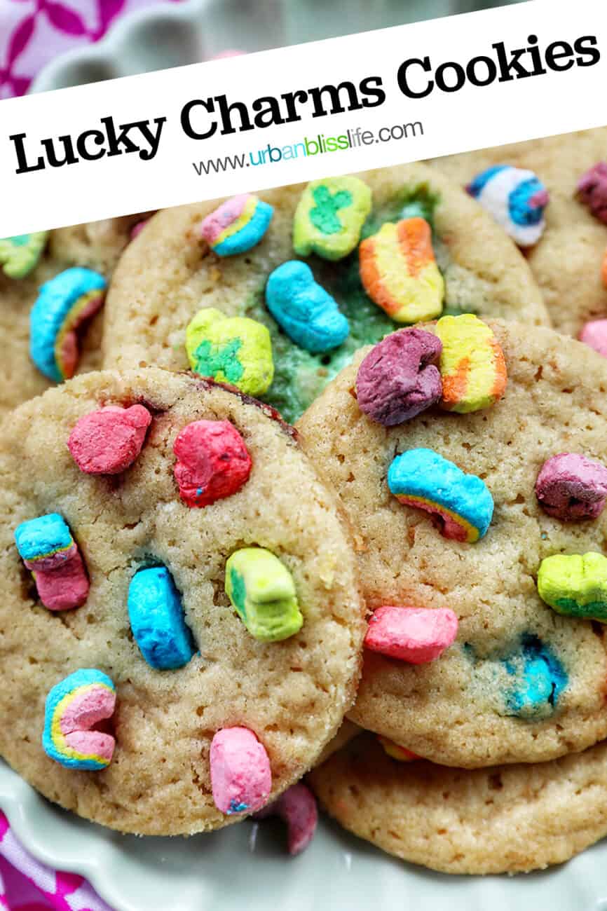 plate full of Lucky Charms Cookies on top of one another at angles with bright colorful marshmallows with text reading Lucky Charms Cookies.