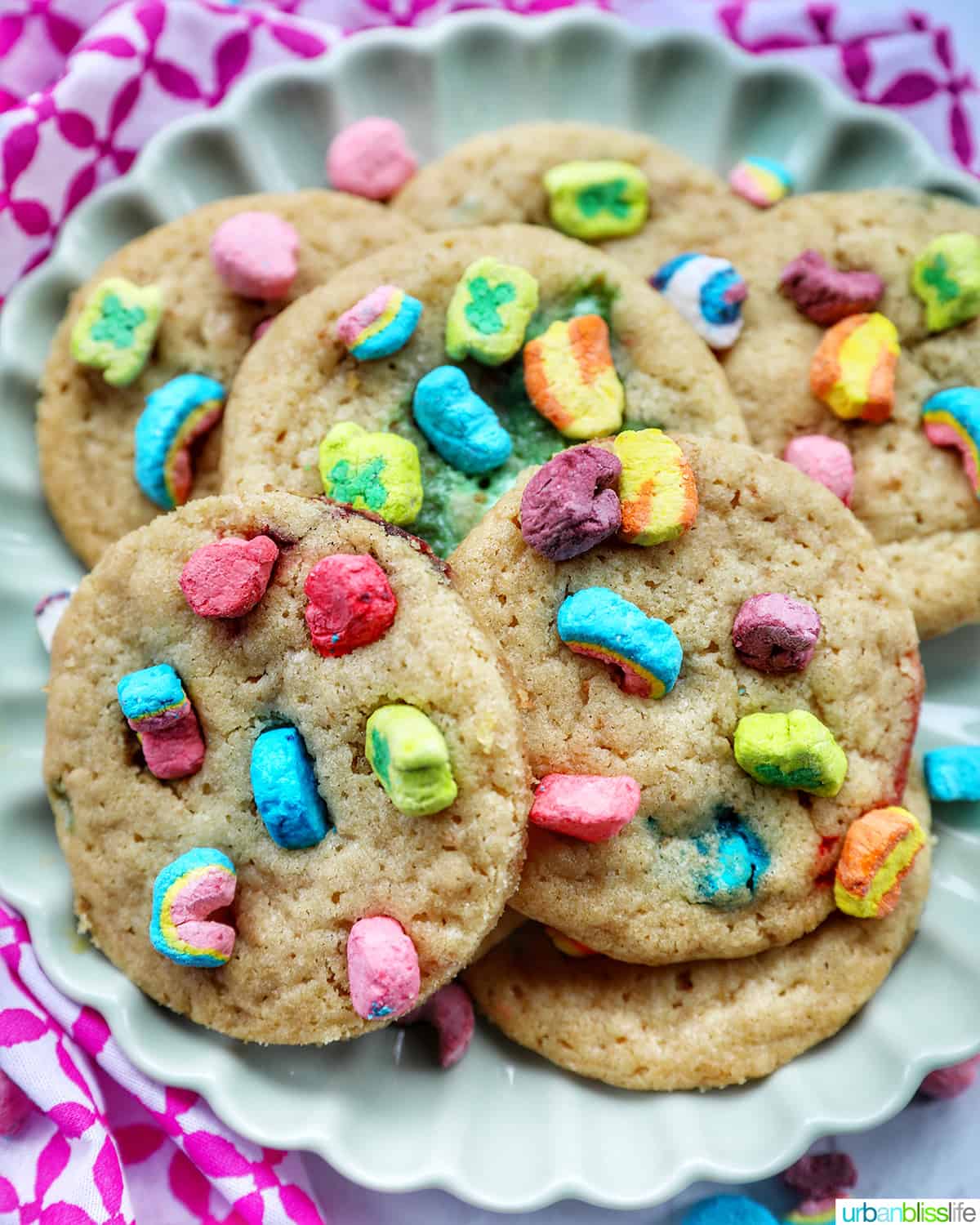 plate with several Lucky Charms cookies stacked, with colorful marshmallows on top.