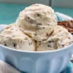 close up of bowl of stracciatella ice cream scoops with bowl of chocolate shavings on the side.