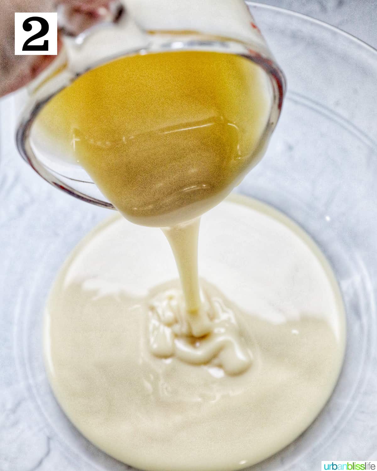 pouring sweetened condensed milk into a large glass bowl.