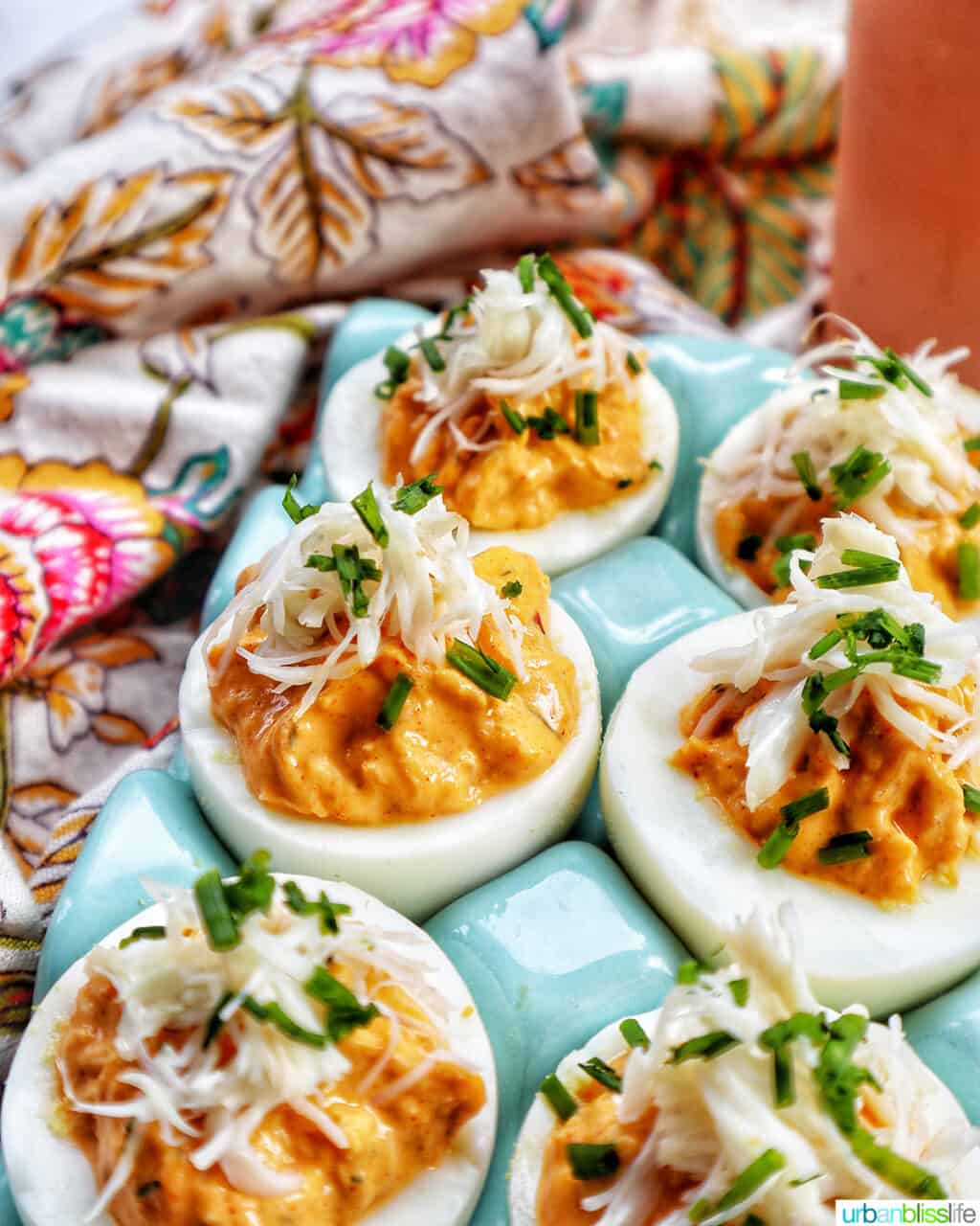six crab deviled eggs in a blue egg holder.