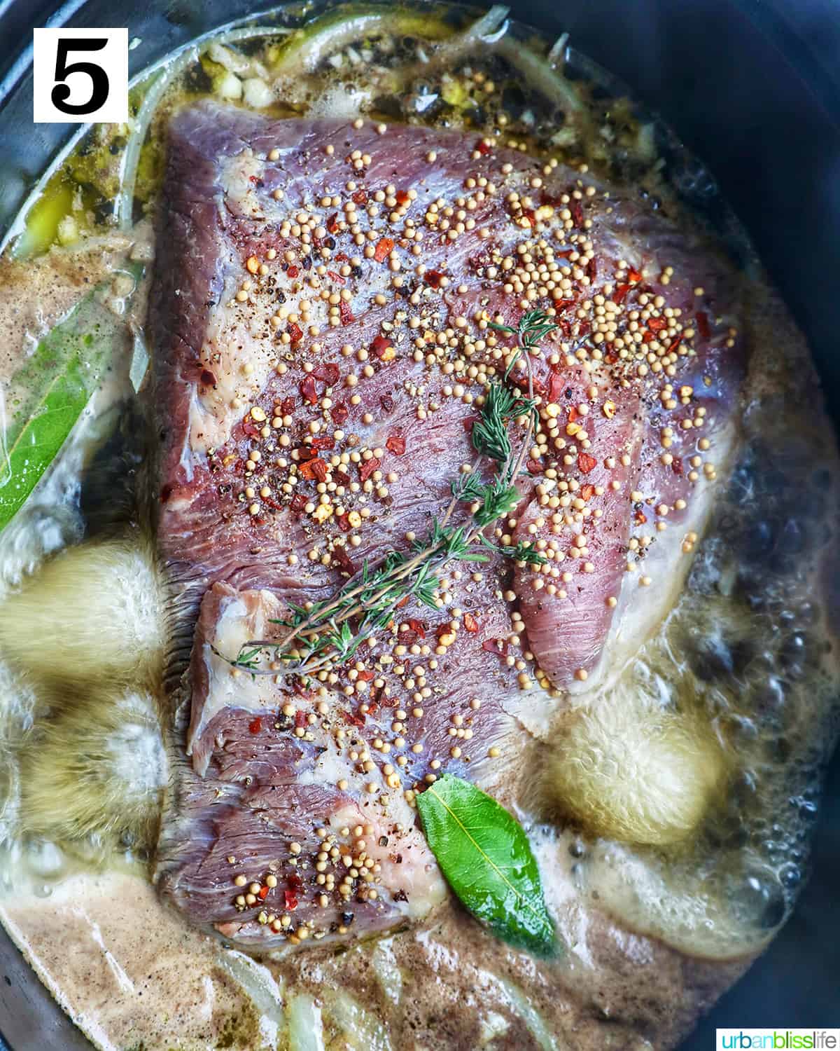 brisket in a Dutch oven with carrots, potatoes, and cabbage.