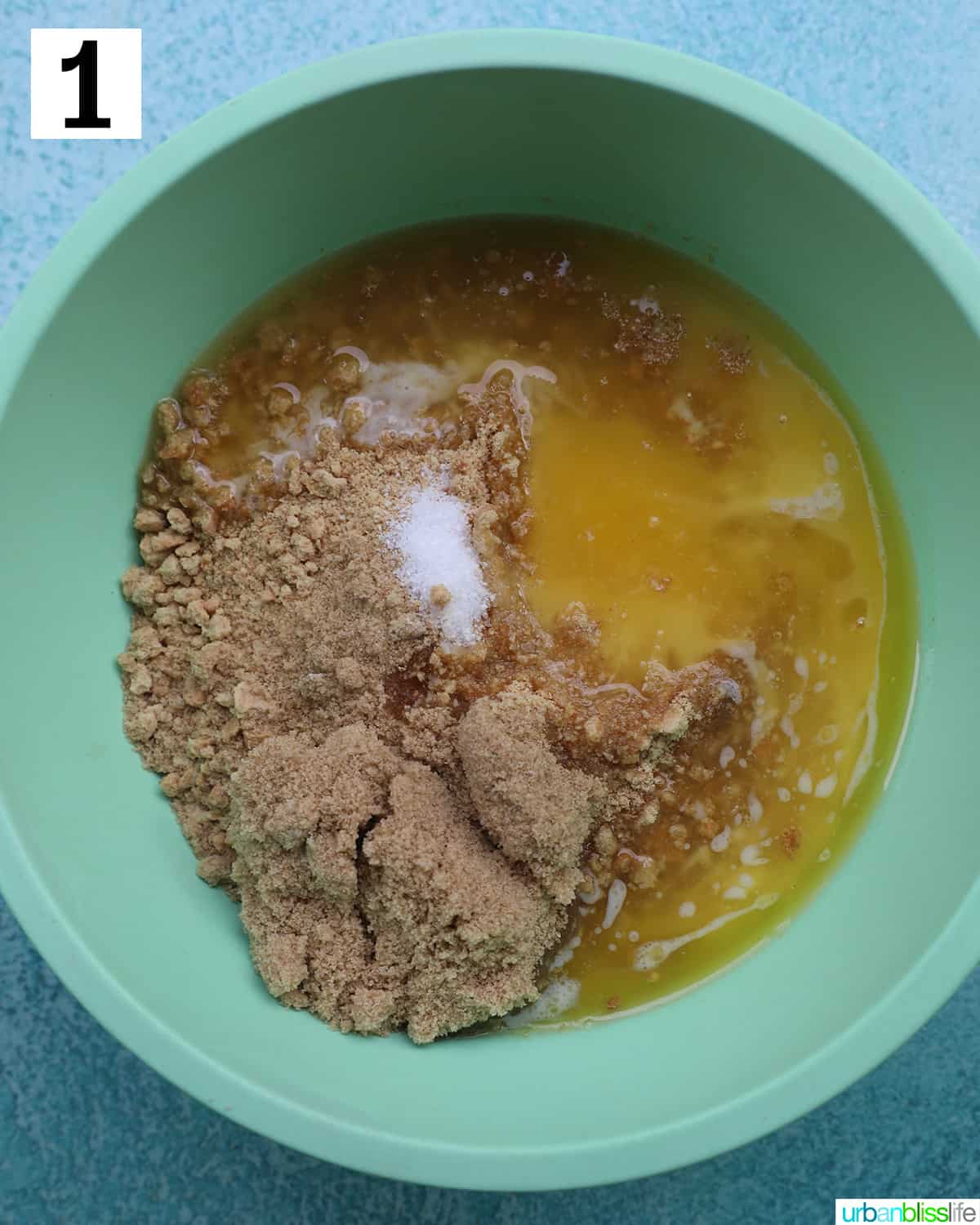 green bowl with ingredients in it to make a cookie crust for cake.