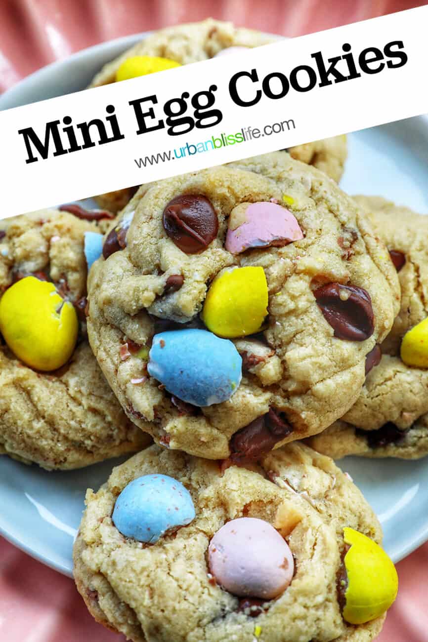 stack of Easter mini egg cookies on a pink scalloped plate with text that reads Mini Egg Cookies.
