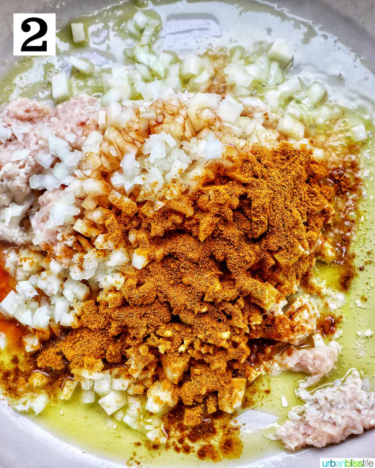 ground chicken, curry powder, and diced potatoes in a pan.