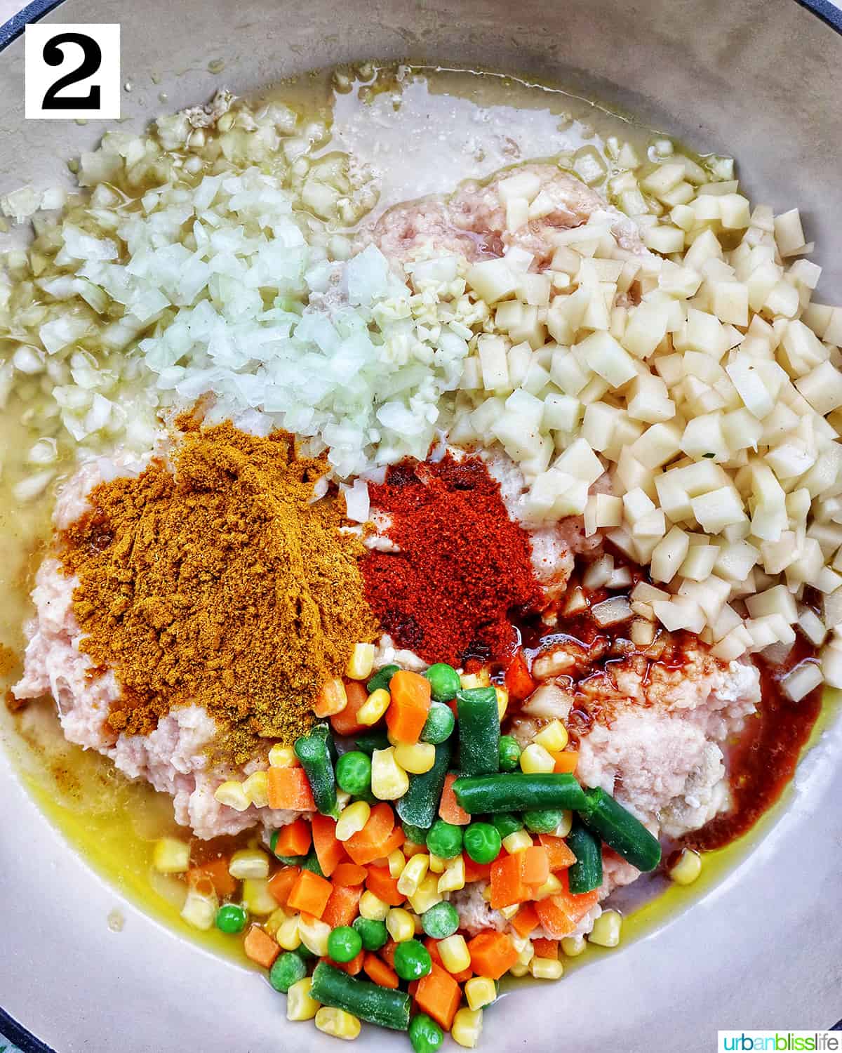 ground chicken, diced potatoes, mixed veggies, and spices in a saucepan.
